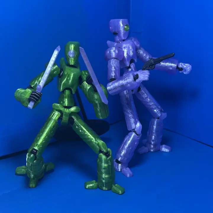 Figuras articuladas impresas en 3D, una verde y una violeta